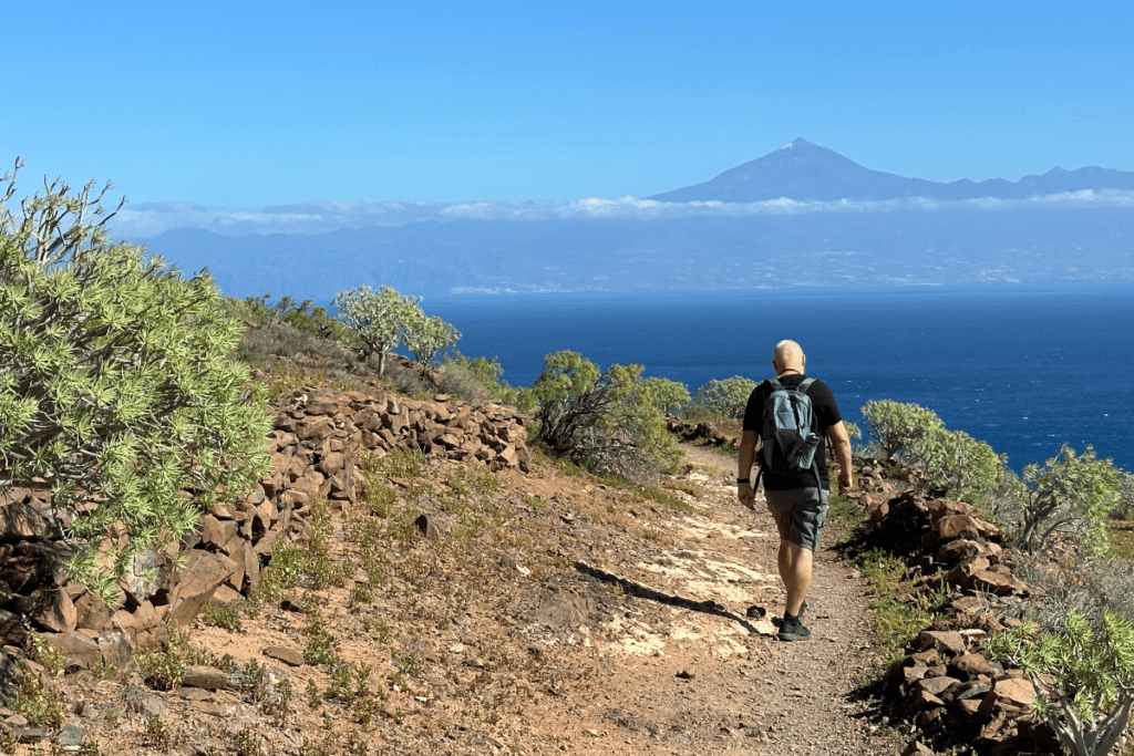 Playa De La Guancha La Gomera a San Sebastian Sentiero escursionistico lungo la cima della scogliera con vista del Monte Teide sullo sfondo Isole Canarie Spagna con cielo blu e mare blu
