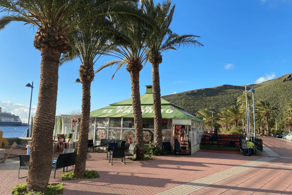 Essens- und Getränkekiosk und Palmen an der Promenade an der Playa De San Sebastian auf La Gomera, Kanarische Inseln, Spanien
