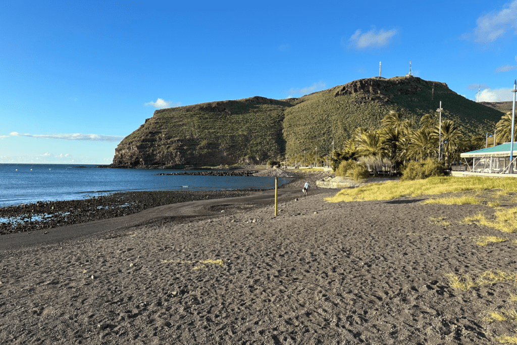 Vulkanische Playa De San Sebastian auf La Gomera, Kanarische Inseln, Spanien, mit steilen Klippen im Hintergrund, einer der besten Strände von La Gomera 