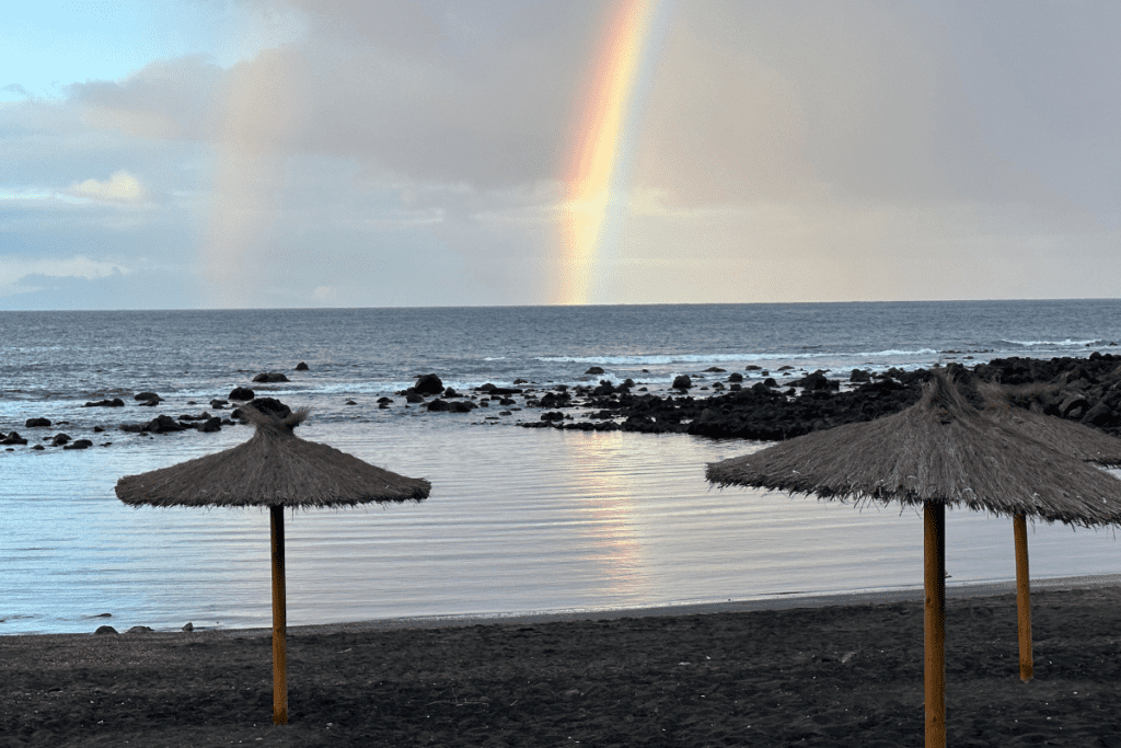 Ein wunderschöner Regenbogen am frühen Morgen spiegelt sich im Wasser von Charco Del Conde La Gomera im Valle Gran Rey Kanarische Inseln Spanien Einer der besten Strände von La Gomera 