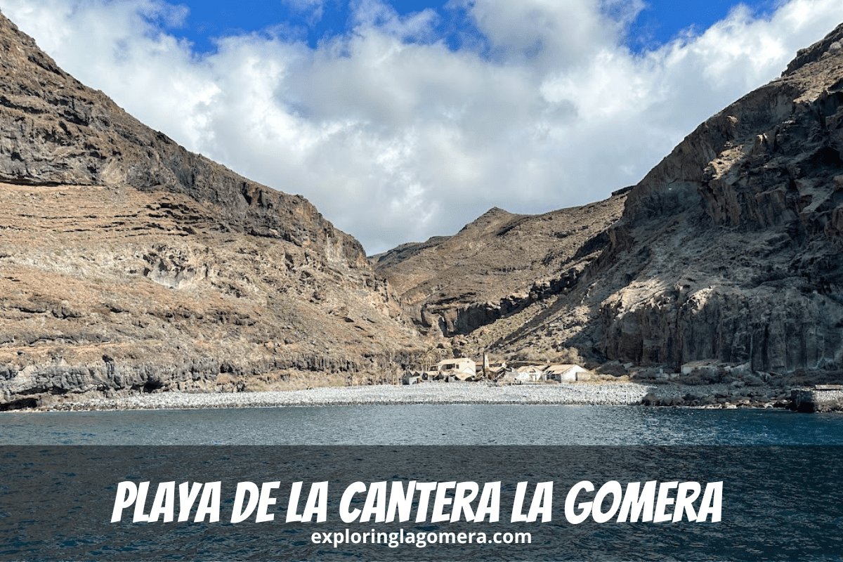 Mar azul y una playa rocosa con montañas y edificios abandonados en segundo plano en Playa de La Cantera La Gomera Islas Canarias España