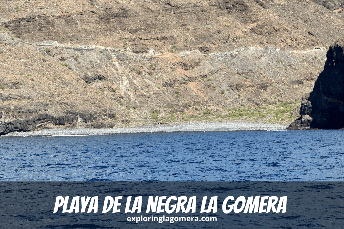 Blaues Meer und ein felsiger Strand, bekannt als Playa De La Negra, La Gomera, Kanarische Inseln, Spanien, mit steilen Bergen im Hintergrund