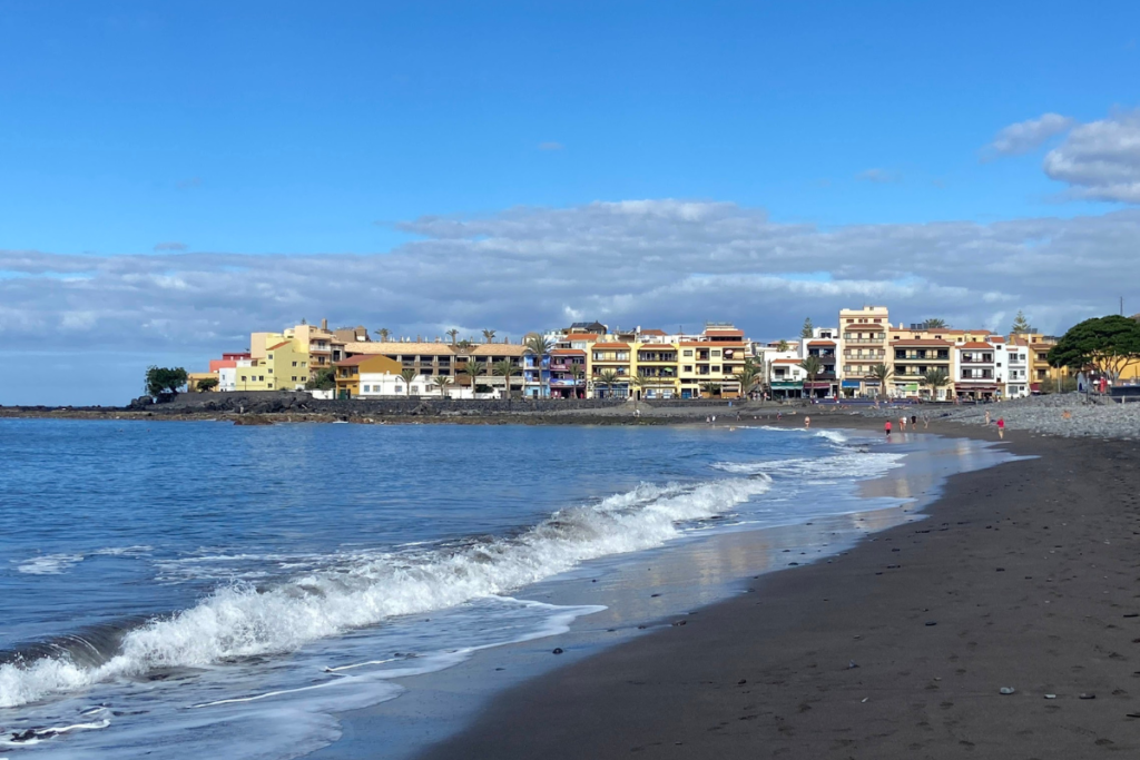 Una playa volcánica de arena y roca llamada Playa de La Calera una de las mejores playas de La Gomera Islas Canarias España con restaurantes en el fondo