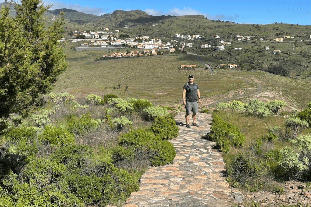 Gepflasterter Wanderweg zur Ermita De San Isidro La Gomera Kanarische Inseln Spanien mit Bergen und dem Dorf Alajero im Hintergrund
