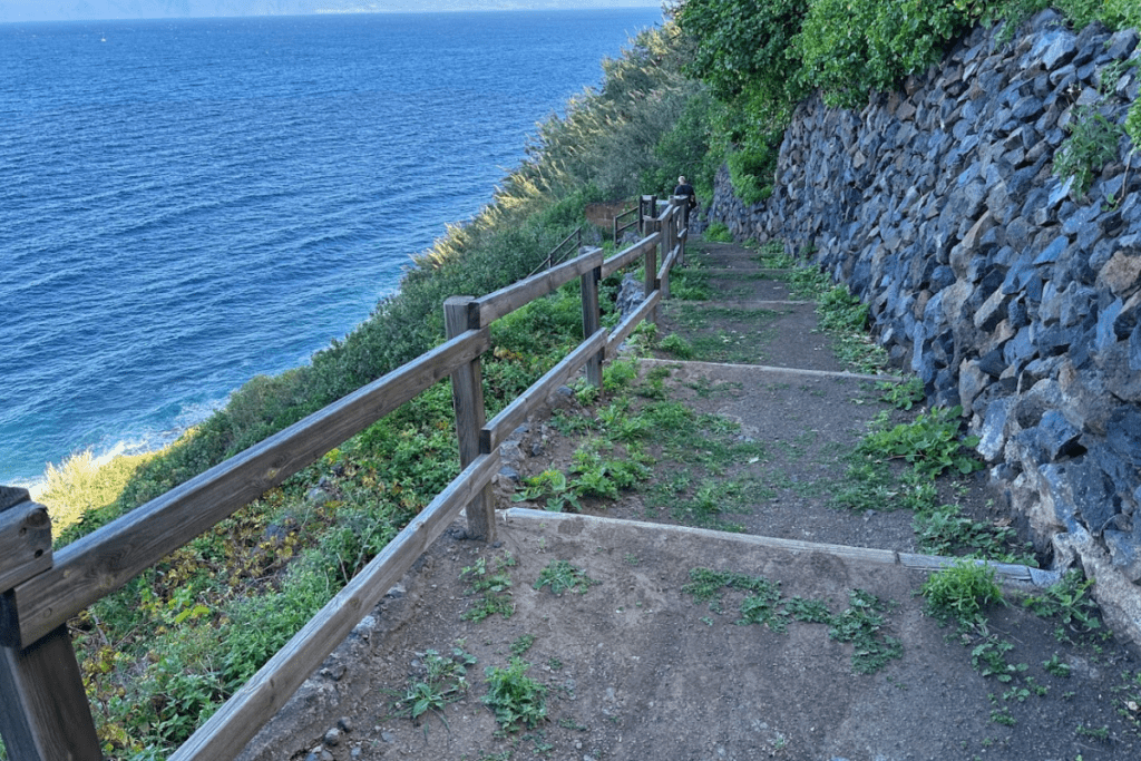 Largos escalones descienden a Pescante de Agulo La Gomera Islas Canarias España con un muro de piedra al lado derecho y el mar azul de fondo