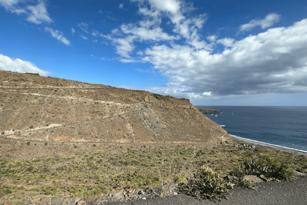 Ruta de senderismo por el acantilado hasta la Playa de Chinguarime La Gomera Islas Canarias España con mar azul y playa en segundo plano.