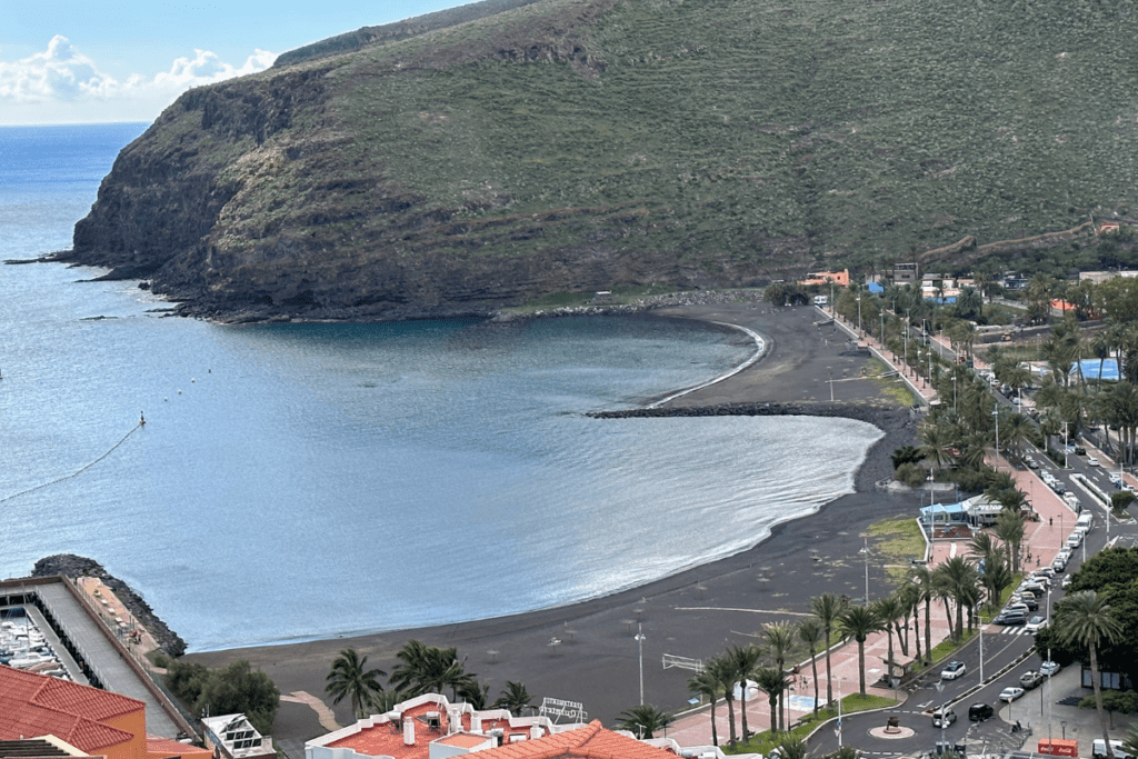 Playa de San Sebastián Vista desde la cima del acantilado con paseo marítimo y acantilados negros Una de las mejores playas de San Sebastián De La Gomera Islas Canarias España