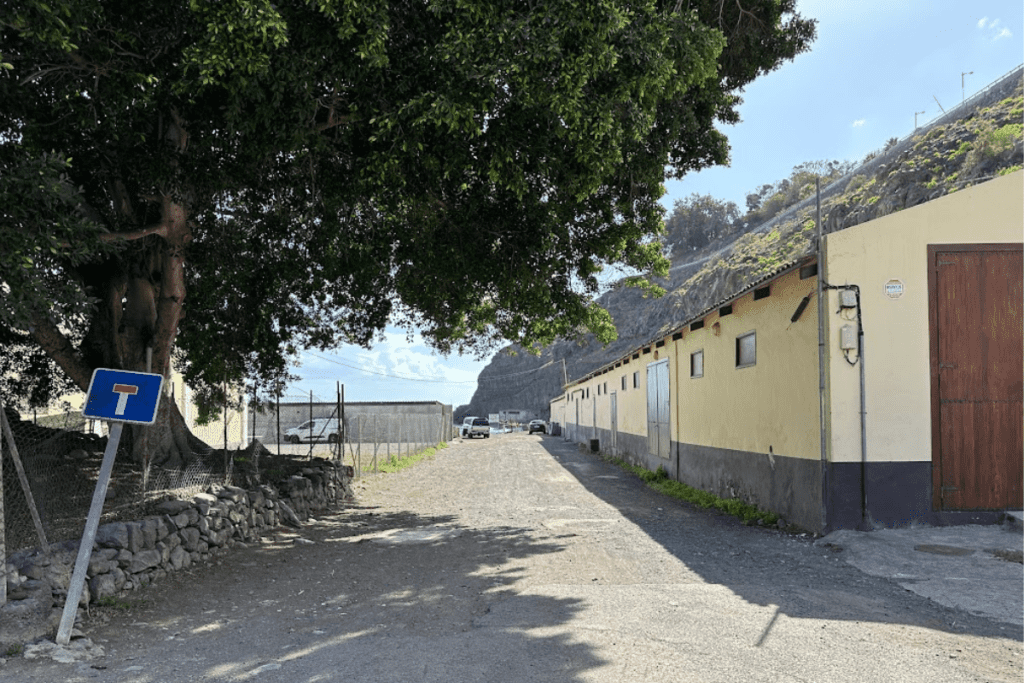 Strada di accesso con edifici a lato a Playa de Tapahuga La Gomera Isole Canarie Spagna con scogliera in background
