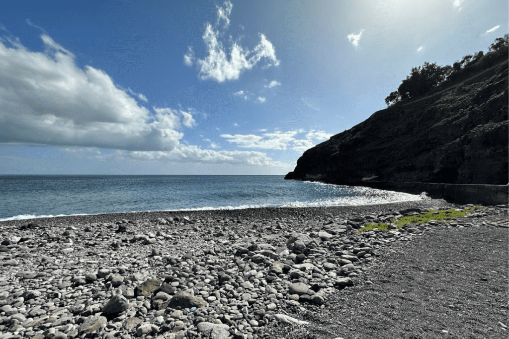 Spiaggia rocciosa e mare blu a Playa de Tapahuga La Gomera Isole Canarie Spagna con il vecchio muro del porto in background